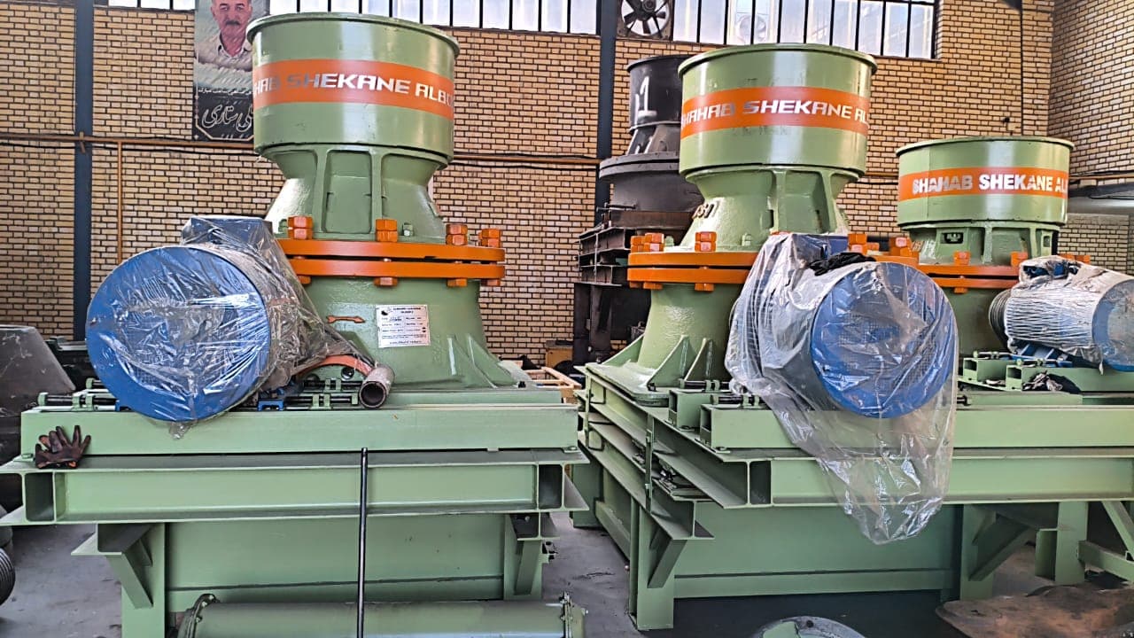 Green and orange Alborz Crusher cone crushers with blue motors in the company workshop